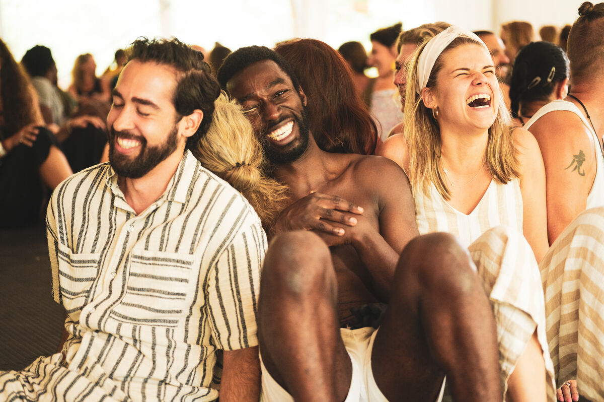Mensen die samen lachen terwijl ze op de vloer zitten tijdens een workshop